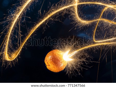 A flying and burning mandarin has a luminous trail behind it.