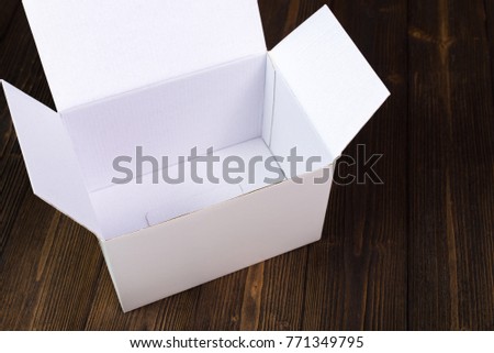 Empty white gift box or tray for mock up on dark wooden table with copy space.