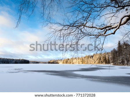 Snowy scenery on a cold morning in Finland. Winter wonderland wallpaper. Sunrise, snow covered lake ice.