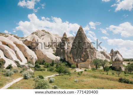 Beautiful view of the hills of Cappadocia. One of the sights of Turkey. The road passes by. A blue sky with clouds in the background.