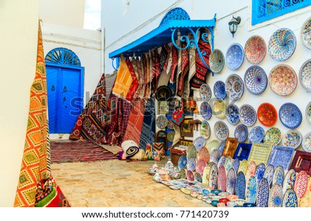 Souvenir earthenware and carpets in tunisian market, Sidi Bou Said, Tunisia. Royalty-Free Stock Photo #771420739