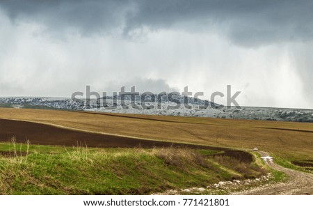 Storm over spring agricultural fields. Aksu dzhabagly
