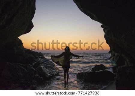 silhouette of a girl in the sunset on the coast