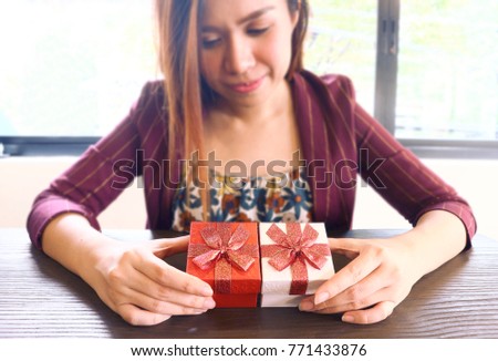 Gifts on the table and background women.                          