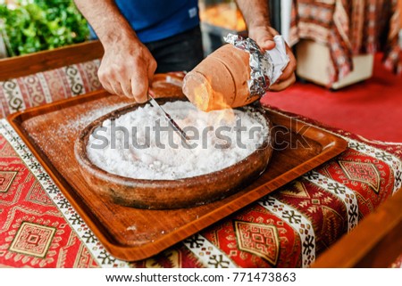 the chef at a Turkish restaurant making a show with Testi Kebab in a clay pot on burning salt. Concept of national Middle Eastern cuisine Royalty-Free Stock Photo #771473863