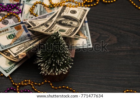 Dollars on a black background with a Christmas tree and toys