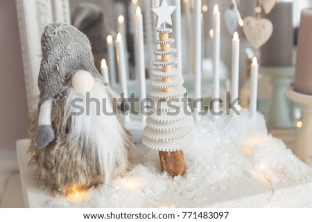 Christmas background. Christmas card. White dresser with mirror decorated with Christmas presents, candles, Santa Claus and lights. Close-up. Selective focus.