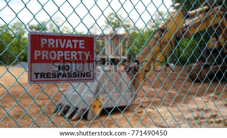 private property sign on green chain link fence with blur background
