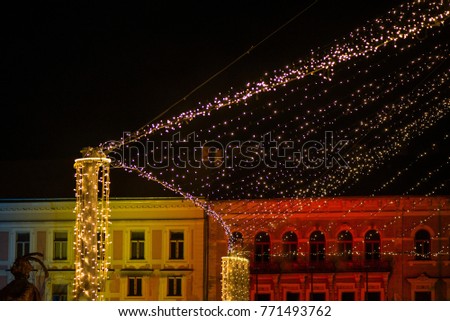 Christmas market and decorations in city center. Glowing light stripes on dark, romantic night sky background