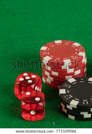 two red dices and different chips on green background. gambling and betting addiction concept