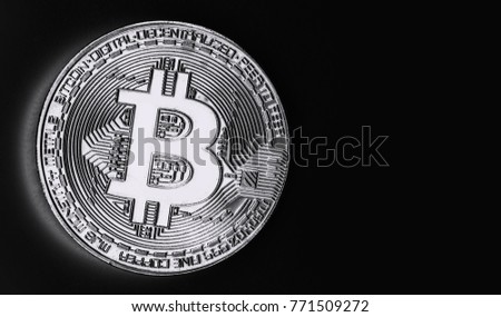 Bitcoin gold coin on black isolated background. Black and white photo.