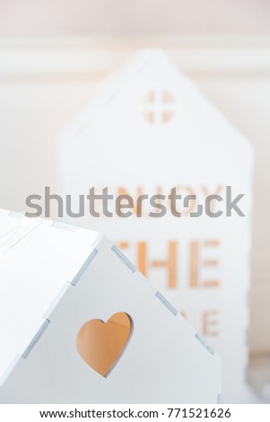 Christmas background. Christmas card. Toy wooden white houses with lights. Clouds of cotton wool with light. Star gold color. Children's room decoration. Selective focus. Close-up.