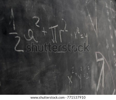 Blackboard inscribed by chalk with math and scientific formulas and calculations 