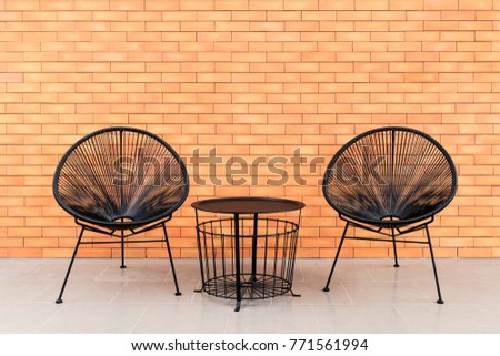 A vintage - modern living outdoor furniture with brick wall background and ray of light