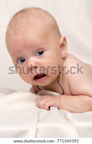 portrait of cute baby. Adorable baby in white sunny bedroom. Family morning at home. Child relaxing on white bed. Textile and bedding for kids. Kid looking into the camera