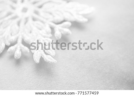 Silver white snowflake in macro closeup on a white background. Soft image, christmas and happy new year. High resolution photography.
