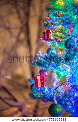Christmas decorations on a branch of fir, night idyll, with snow and lamps in various colors
