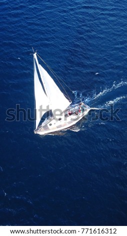 Aerial drone bird's eye view of sailboat cruising in deep blue sea