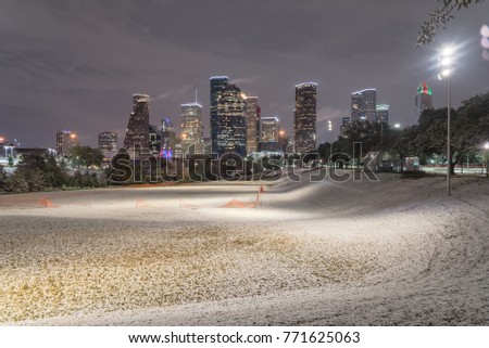 Unusual snow in Downtown Houston with big and fluffy snowflakes fell on meadow grass at Eleanor Park. Snow is extremely rarely happen and it has only fallen in Houston 35 times since February 1895.