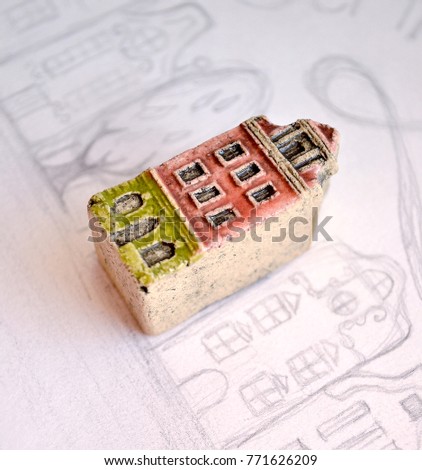 A special miniature house that stands out between the others. Old architecture. Motivation to stand out.