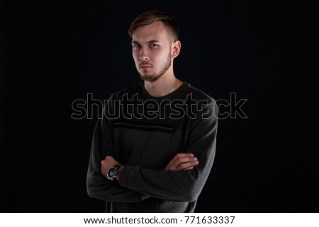 The guy is half-turned on a black background