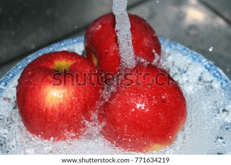 
apples are washed under a stream of cold water.