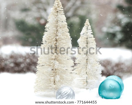 White Christmas Trees and Shiny ornaments in the cold Snow