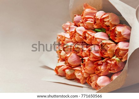 Bouquet of orange tulips closeup on background of Kraft paper, selective focus, natural background.