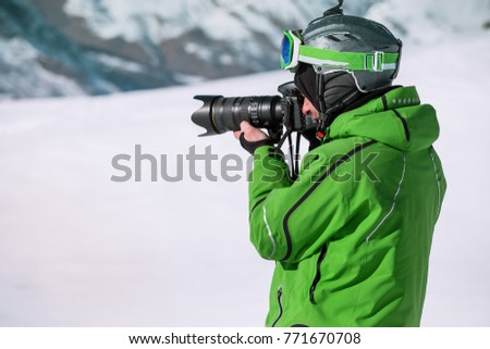 skier photographing mountain with professional camera