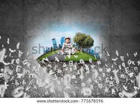 Young little boy keeping eyes closed and looking concentrated while meditating on flying island among flying letters with gray dark wall on background. 3D rendering.