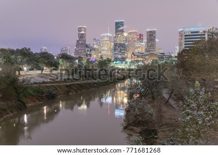Unusual snowfall along Bayou River bank with downtown Houston, Texas, USA skylines city lights reflection at sunrise/twilight. Snow is extremely rarely in Houston and happen only 35 times since 1895