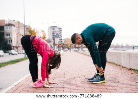 Couple stretching outdoors after training.