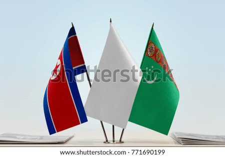 Flags of North Korea and Turkmenistan with a white flag in the middle