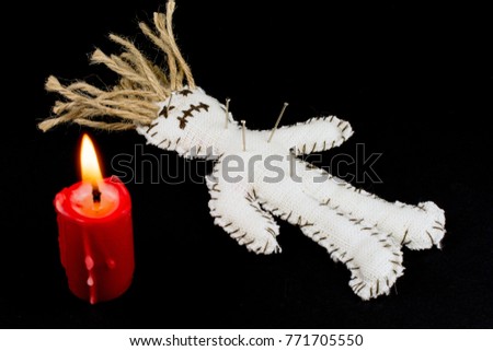 voodoo doll needles and pins red candle, smoke and fire on a black background close up selective focus, witchcraft concept