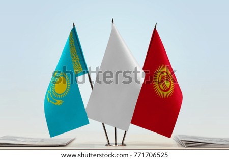 Flags of Kazakhstan and Kyrgyzstan with a white flag in the middle