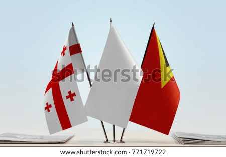 Flags of Georgia and East Timor with a white flag in the middle