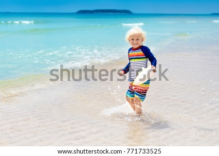 Child on beautiful beach. Little boy running and jumping at sea shore. Ocean vacation with kid. Children play on summer beach. Water fun. Kids run and swim. Family holiday on tropical island