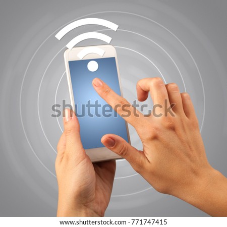 Female fingers touching smartphone with wireless connection icon