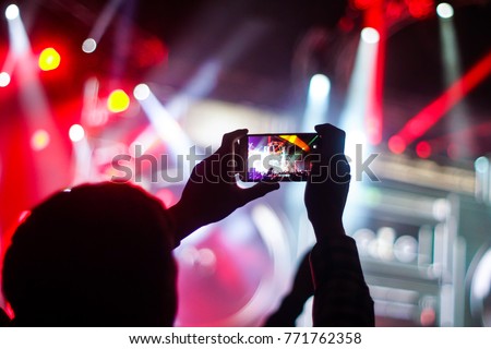 Close up of photographing with smartphone during a concert