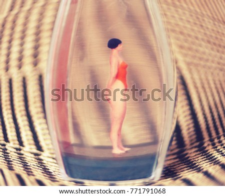 Tiny woman or girl in a glass box. Body issues concept or unrealistic standards of beauty. Depicted in miniature with Instagram filters and soft focus. Eating disorders, body dysmorphia.  Royalty-Free Stock Photo #771791068