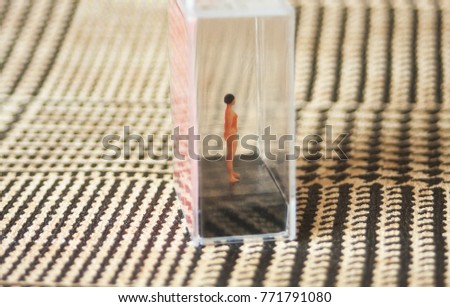 Tiny woman or girl in a glass box. Body issues concept or unrealistic standards of beauty. Depicted in miniature with Instagram filters and soft focus. Eating disorders, body dysmorphia.  Royalty-Free Stock Photo #771791080
