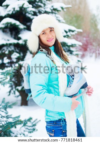happy young woman going ice-skating outdoor  in wintertime