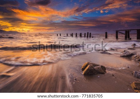Motion waves with a view of an old jetty at sunset with beautiful sunset color at background