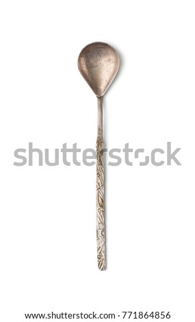 An old shabby teaspoon with a long, elegant handle. Isolated on white background.
