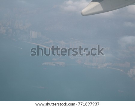 An over exposure picture of Airplane wing, behind is far view landscape of Hong Kong country.