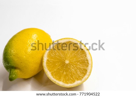 Textured ripe slice of lemon citrus fruit isolated on white background. Group of ripe whole yellow lemon citrus fruit with lemon fruit half isolated on white background with clipping path