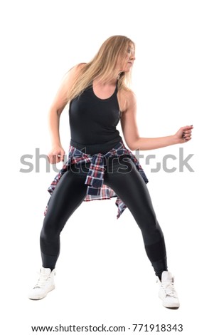 Blonde young woman dancing dancehall aerobics and moving arms looking away. Front view. Full body length portrait isolated on white background.