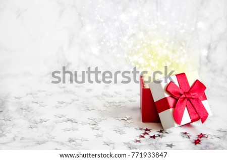 white box with a red bow on a marble table