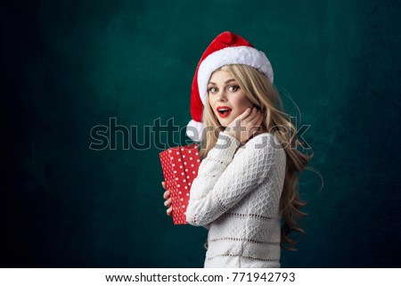 woman with a New Year's gift, with a Santa Claus hat on his head, a holiday                              