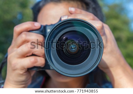 Close up young woman photographing with camera outside